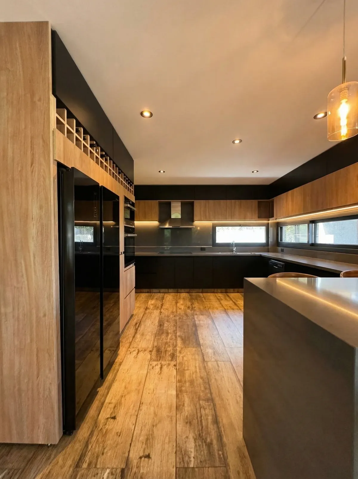 Cocina diseñada por Ramos Arquitectura con mesada de cuarzo, muebles de madera y equipamiento premium integrado